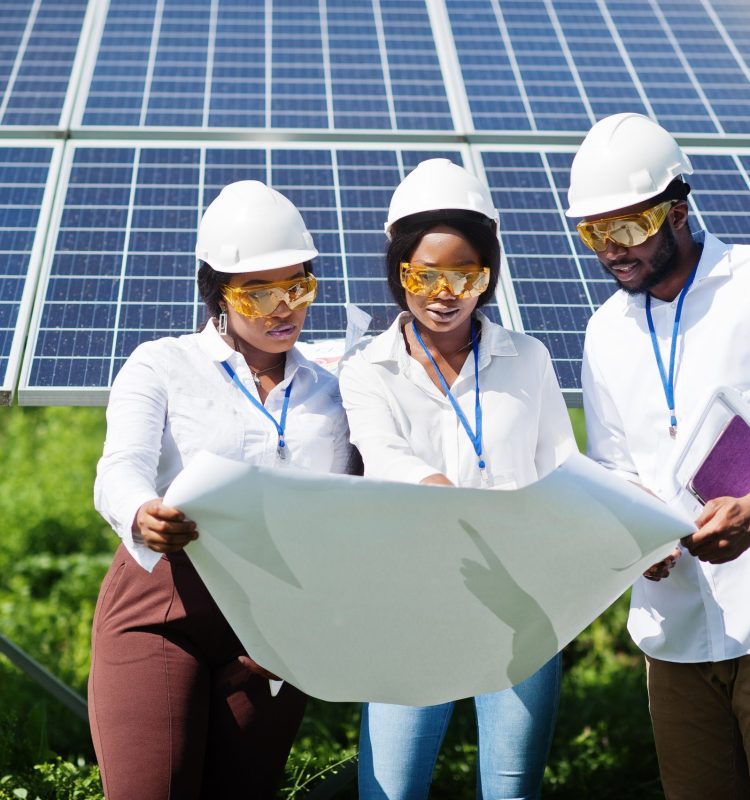 African american technician checks the maintenance of the solar panels. Group of three black engineers meeting at solar station.